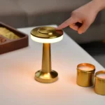 Touch control on top of the gold cordless table lamp giving a warm light