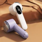 Beige and purple fabric shavers on cloth showing perforated mesh head, side button and charging port